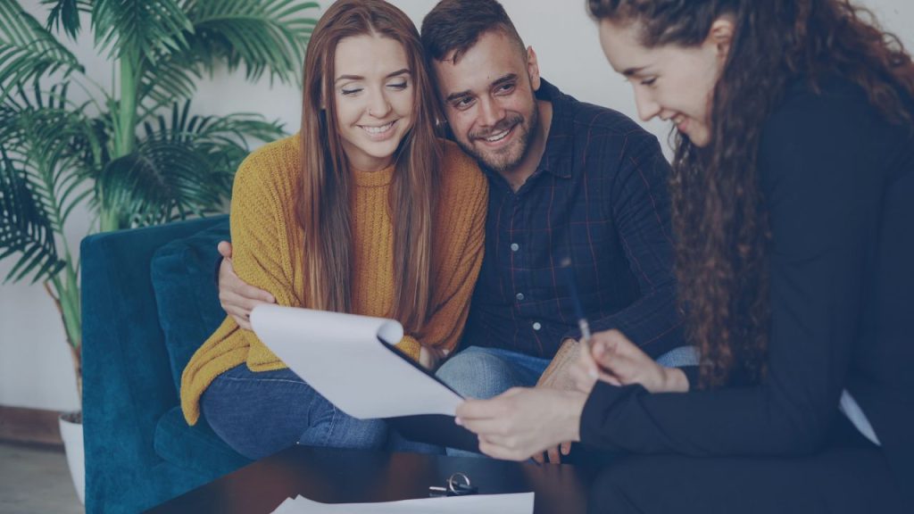 pexels-photo-36729962-36729962 Happy couple discussing finance with advisor in cozy office setting.